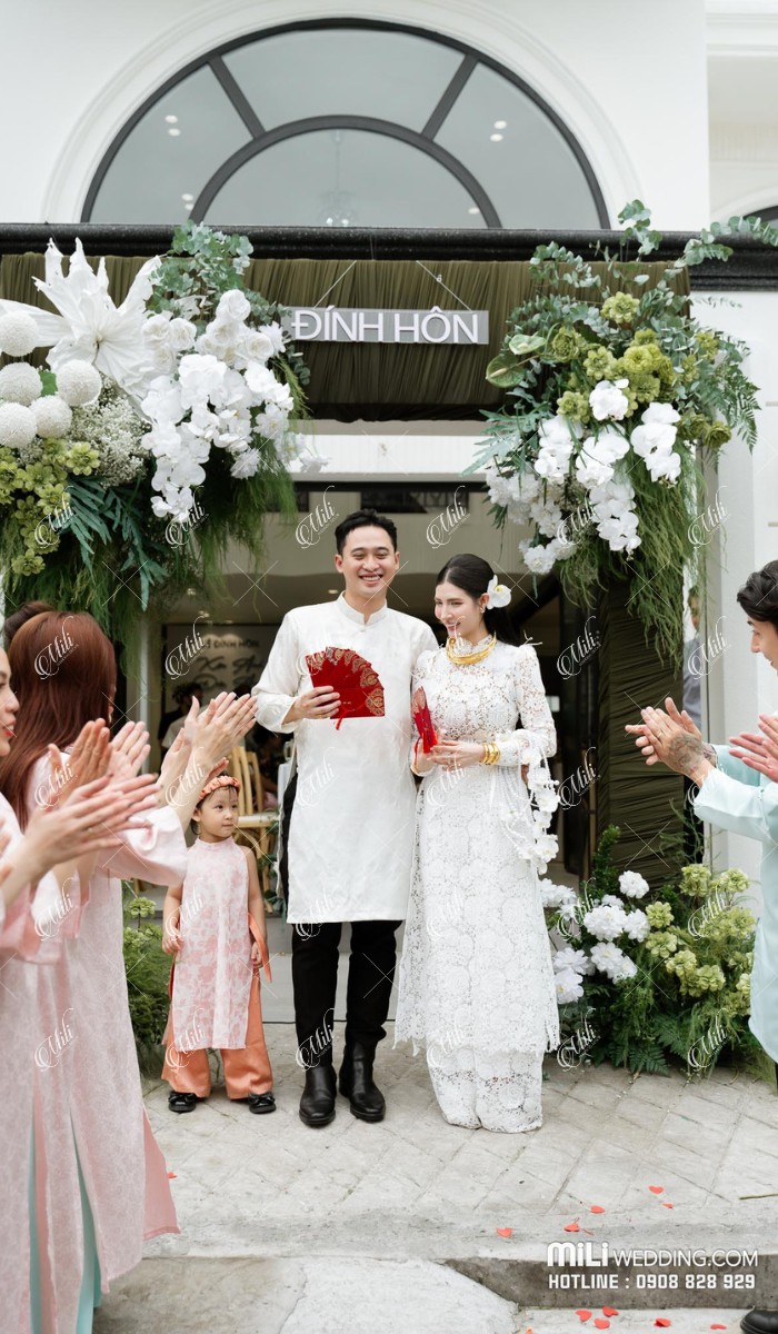 Kim Anh và Đức Anh bước qua cổng hoa xanh trắng