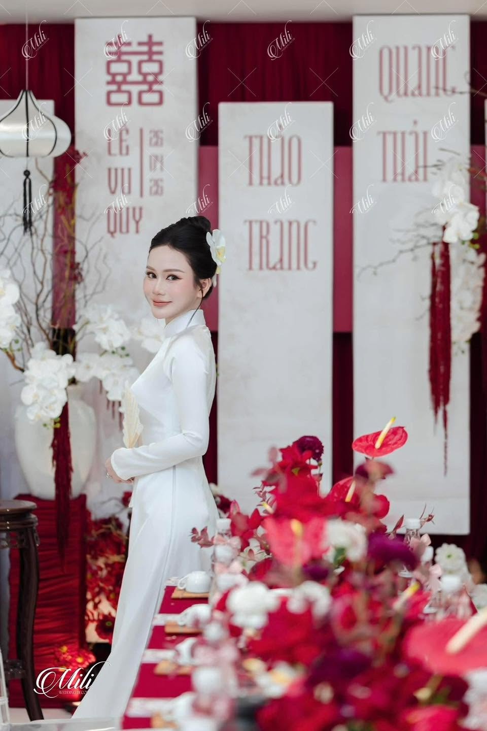Chân dung cô dâu áo dài trắng trước phông lễ đỏ trắng